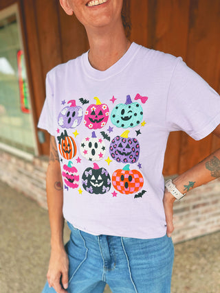 Multi Pumpkin Collage tee with colorful jack-o'-lanterns modeled by an A Gathering Place team member