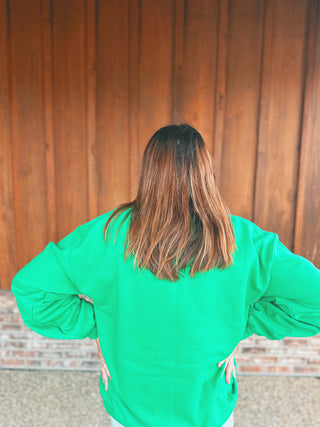 Green crewneck sweatshirt with embroidered Grinch face on the left chest