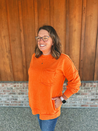 Zenana orange acid wash French terry pullover, modeled by an A Gathering Place team member
