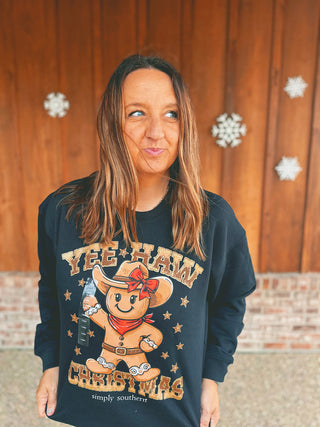 Simply Southern black sweatshirt with cowboy gingerbread design, modeled by an A Gathering Place team member