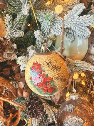 Poinsettia ball ornament with red blooms and green leaves